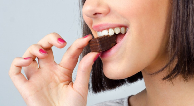 Donna che morde il cioccolato